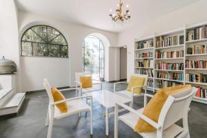 een eetkamer met witte stoelen en een tafel en boekenplanken bij Casa Amatissima in Brezzo