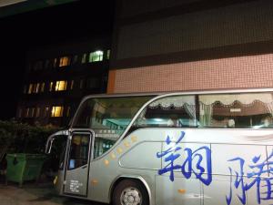 a white bus with blue writing on the side of it at San Ho Business Hotel in Xiluo