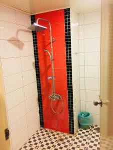 y baño con ducha y pared roja. en San Ho Business Hotel, en Xiluo