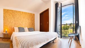 - une chambre avec un lit et une grande fenêtre dans l'établissement Azuleixo, à Aveiro