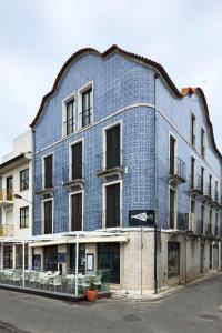 a blue brick building with tables on a street at Azuleixo in Aveiro
