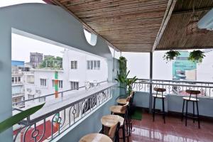 einen Balkon mit Stühlen und Tischen auf einem Gebäude in der Unterkunft La Ava’s Home in Hanoi