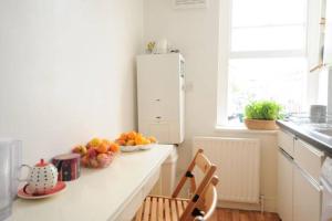 a kitchen with a counter with a bowl of fruit on it at Fantastic location! in London