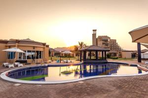 einem Pool mit Pavillon und einem Gebäude in der Unterkunft Royal Beach Hotel & Resort in Dibba