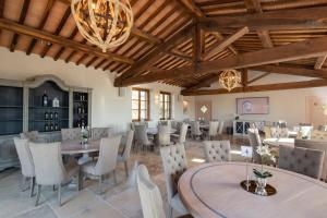 a dining room with tables and chairs and a chandelier at Borgo Argiano in Castelnuovo Berardenga