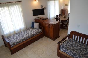 Habitación con 2 camas, mesa y TV. en Paihue Cabañas en Valeria del Mar