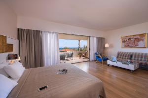 una camera d'albergo con un letto e un soggiorno di Kassandra Palace Seaside Resort a Kriopigi