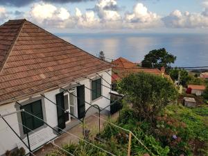 ein weißes Haus mit rotem Dach und Meer in der Unterkunft Paradise View in Gaula