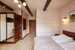 a bedroom with wooden walls and a bed in a room at Zlata in Bukovel