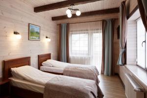 1 dormitorio con 2 camas y ventana en Zlata en Bukovel