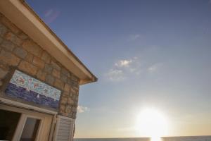 a building with the sun shining on the ocean at Villa Ada in Agropoli