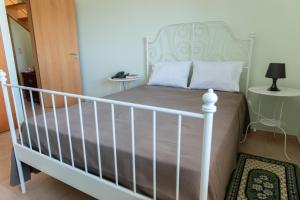 - une chambre dotée d'un lit avec un cadre blanc dans l'établissement Casa dos Cabecinhos, à Oliveira do Hospital