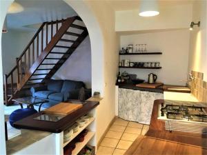 a living room with a blue couch and a staircase at La maison Vigne Vierge in Lagrasse