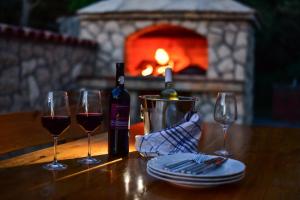 a table with two wine glasses and a bottle of wine at Vacation house Nina in Sukošan +9 photos