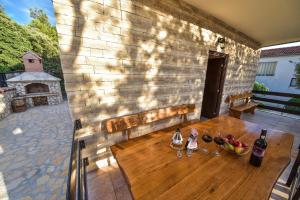 a patio with a wooden table and bottles of wine at Vacation house Nina in Sukošan
