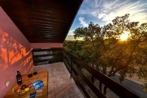 a balcony with a table with wine glasses and the sunset at Vacation house Nina in Sukošan