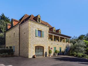 une grande maison en briques avec un toit dans l'établissement Hôtel Bon Encontre, à Sarlat-la-Canéda