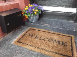 a welcome mat in front of a door with flowers at 39 Cowley Road in Liverpool