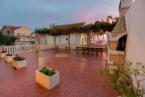 a patio with potted plants and a table on a building at Vila Vukotić in Petrovac na Moru