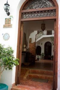 eine offene Tür in ein Zimmer mit einer Treppe in der Unterkunft Dar Manara - Medina d'Asilah in Asilah