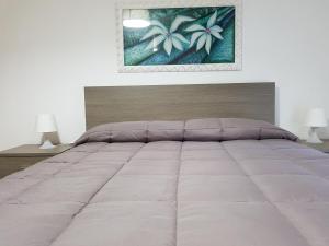 sypialnia z dużym białym łóżkiem z 2 lampami w obiekcie Locazione Turistica "nta Casuzza" w mieście Ragusa