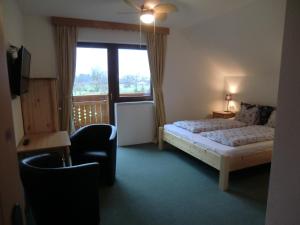 a bedroom with a bed and a window and a chair at Haus Rye in Obertraun