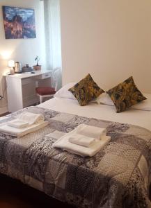 Dreaming Piazza Bra Rooms في فيرونا: سرير وفوط جالسين عليه