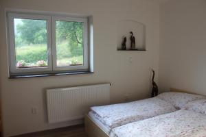 a bedroom with a bed and a window at Apartmán Beskydy in Halenkov