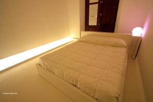 a bedroom with a bed with a light on it at Diecizero Affittacamere in Barùmini