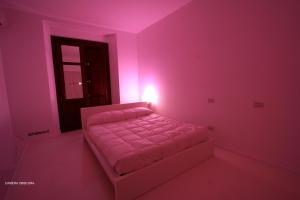 um quarto com uma cama num quarto cor-de-rosa em Diecizero Affittacamere em Barumini