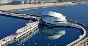 un gran edificio en el agua junto a una playa en Quarto junto ao mar, en Matosinhos