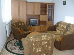 a living room with two couches and a tv at PENZION EUROPA Diakovce in Diakovce