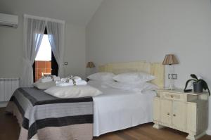 a bedroom with a white bed with white pillows at Enoturismo Lagar De Costa in Castrelo