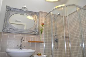a bathroom with a sink and a shower with a mirror at Enoturismo Lagar De Costa in Castrelo