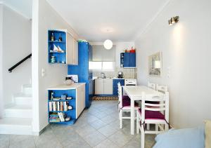 a kitchen with blue cabinets and a table in a room at VILLA SUNSET 1 in Paralia Vrachou