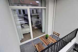 a balcony with a wooden bench and a table at Rent a Flat - Bruxelles in Brussels