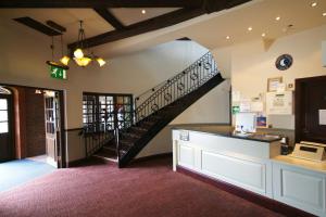 a lobby with a staircase in a building with a store at Windmill Farm Lincoln by Greene King Inns in Lincoln