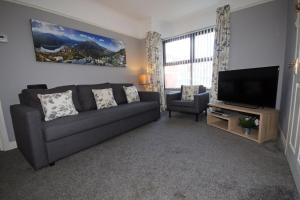 a living room with a couch and a flat screen tv at Modern Belfast Apartment in Belfast