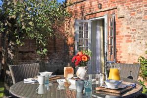 an outdoor table with a table cloth and flowers on it at The Mill, Long Melford in Long Melford +39 photos