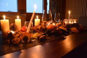 a table with candles and pumpkins and wine glasses at Il Nido dei Sogni in Sanzeno