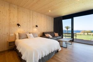 a bedroom with a large bed and a large window at Cabañas de Canide in A Coruña