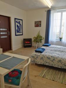 a bedroom with two beds and a table and a fireplace at La Garde Chambres d'hôtes in Charancieu