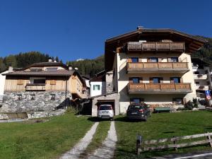 a large building with a car parked in front of it at Appartamento Vista Dolomiti by GoNewLocation in Moena