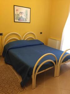 a bedroom with a blue bed with two chairs at The Orange House in Assemini