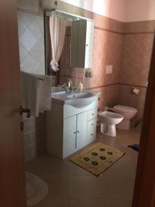 a bathroom with a sink and a toilet at The Orange House in Assemini