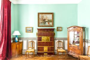 uma sala de estar com duas cadeiras e um relógio avô em Le Fassardy em Châteauroux
