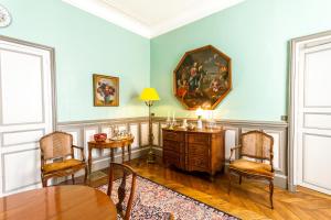 una sala da pranzo con tavolo, sedie e un dipinto sul muro di Le Fassardy a Châteauroux
