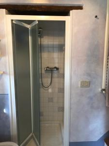 een douche met een glazen deur in de badkamer bij Antico Casale Silvia in Alberoro