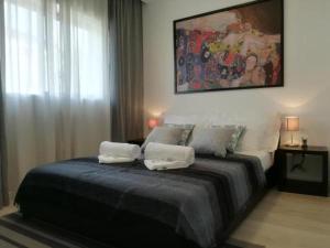een slaapkamer met een bed met twee handdoeken erop bij Irís Apartment in Pombal