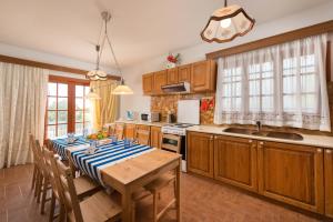 uma cozinha com uma mesa com uma toalha de mesa azul e branca em Villas Marianna em Kalavárda